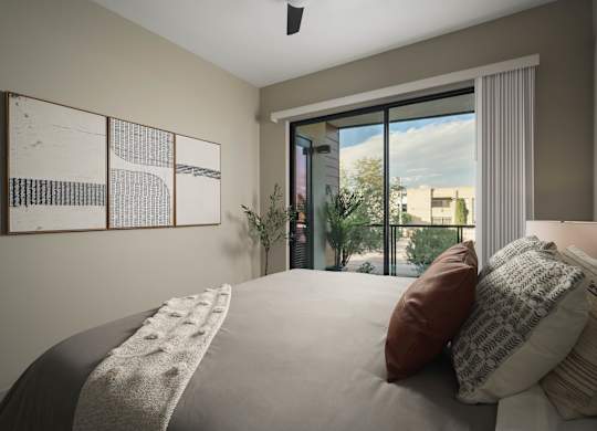 A bedroom with a large bed and a view of the city through the window.