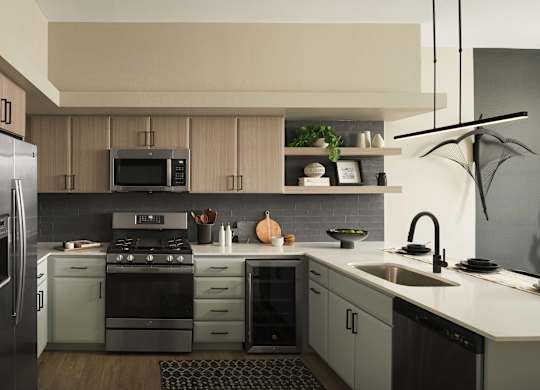 A modern kitchen with a refrigerator, stove, and sink.