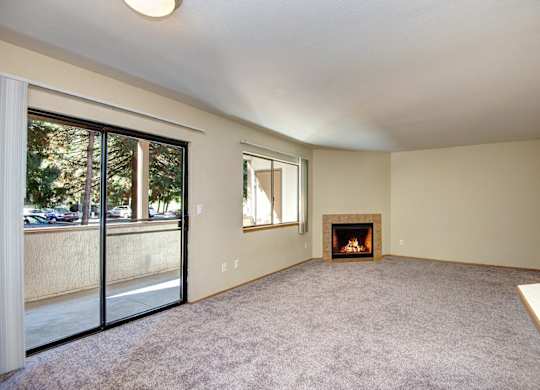A room with a fireplace and sliding glass doors. at Autumn Village, Washington