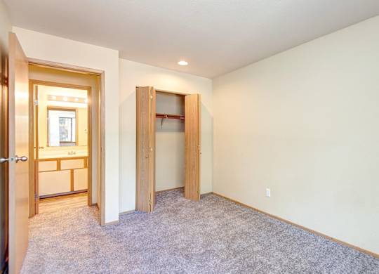 A room with a carpeted floor and a doorway leading to another room. at Autumn Village, Washington, 98354