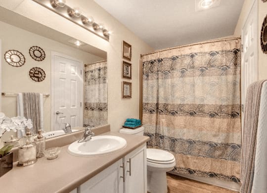 A bathroom with a floral shower curtain and a white sink. at The Retreat, Sumner, Washington