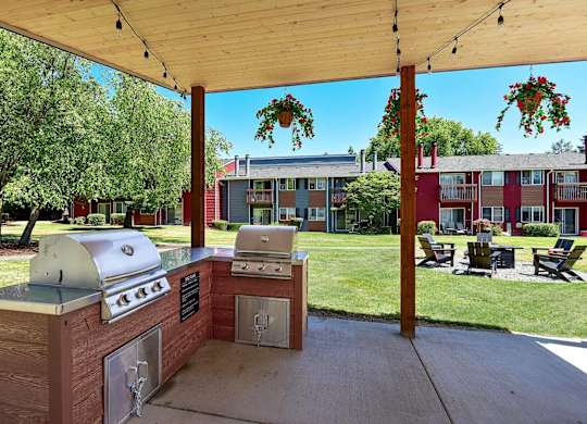 A barbecue grill is set up under a wooden canopy. at Brookstone, Washington, 98198