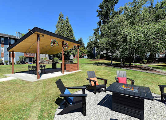A wooden pavilion with a table and chairs is surrounded by a grassy area. at Brookstone, SeaTac