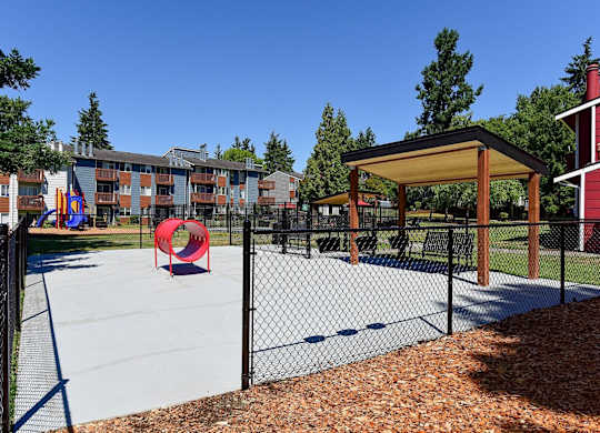 A playground with a red slide and a black fence. at Brookstone, Washington, 98198