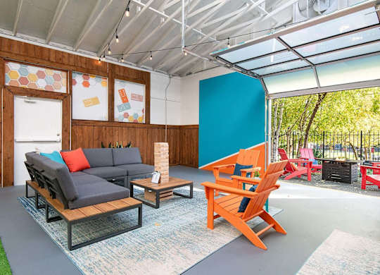 A room with a grey sofa and orange chairs. at Brookstone, Washington, 98198