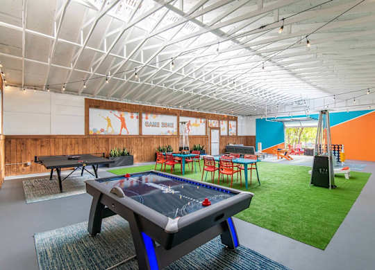 A pool table is in the middle of a room with a foosball table and a ping pong table. at Brookstone, SeaTac, Washington