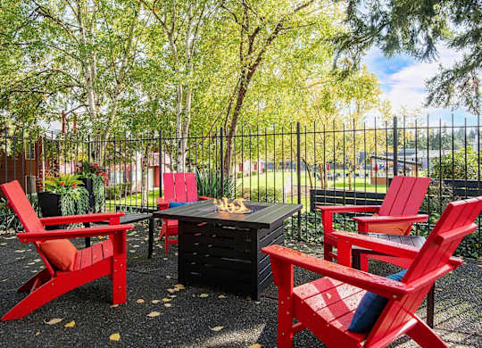 A black table surrounded by red chairs in a backyard. at Brookstone, Washington