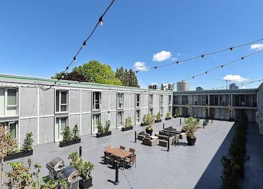 a courtyard with seating and plants on a sunny day at Cosmopolitan, Seattle