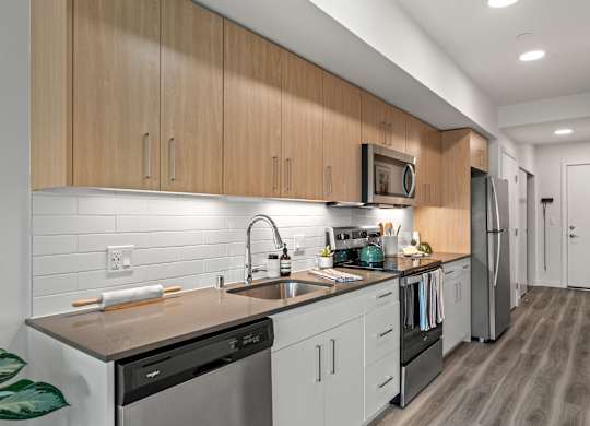 a kitchen with white cabinets and stainless steel appliances and a sink at Baldwyn, Seattle, WA 98125