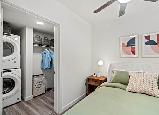 a bedroom with a bed and a washer and dryer and a closet at Baldwyn, Seattle