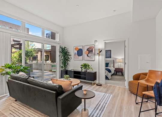 a living room with a couch and a coffee table and large windows at Baldwyn, Seattle, 98125