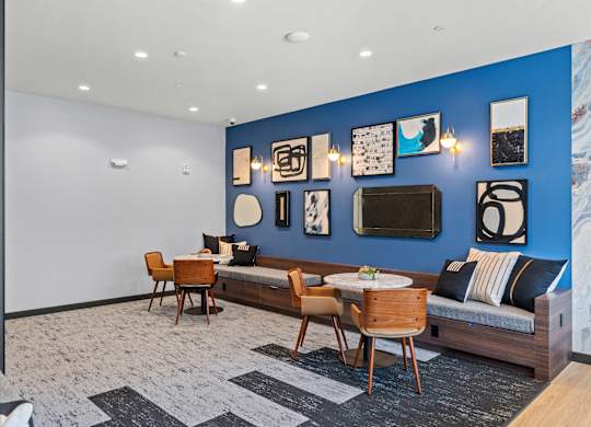 a living room with blue walls and furniture and a table and chairs at Baldwyn, Seattle, WA