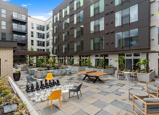 an outdoor patio with tables and chairs at an apartment building at Baldwyn, Washington, 98125