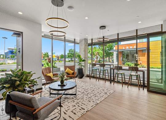 a living room with large windows and a table with chairs at Baldwyn, Seattle, WA