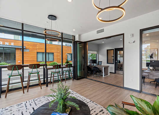 a living room with glass sliding doors and a dining room with a table and chairs at Baldwyn, Seattle, WA 98125
