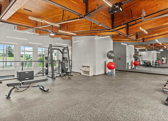 A gym with a wooden ceiling and various exercise equipment.