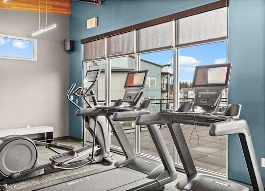A gym with treadmills and a bench.