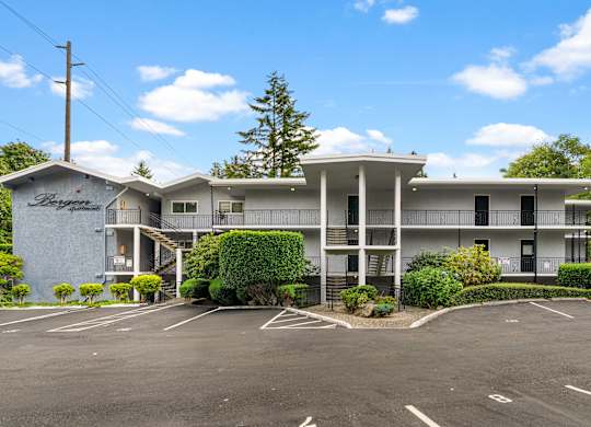 A large white building with a parking lot in front.