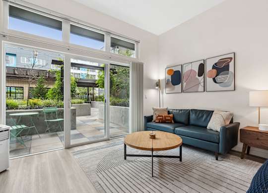 a living room with a couch and a coffee table and sliding glass doors