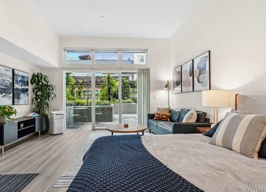 a bedroom with a bed and a sliding glass door to a balcony