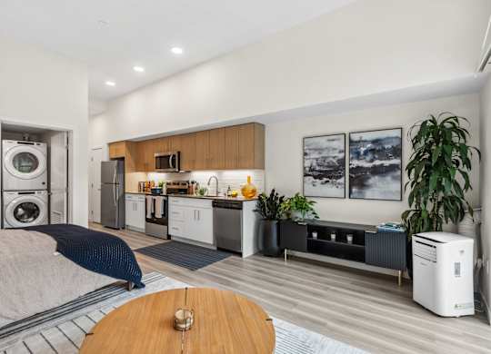 a bedroom with a bed and a kitchen with a washer and dryer
