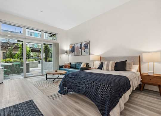 a bedroom with a large bed and a sliding glass door to a patio