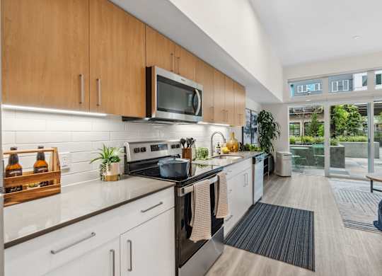 a kitchen with white cabinets and stainless steel appliances and a sliding glass door
