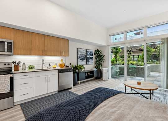 a bedroom with a bed and a kitchen with a large window