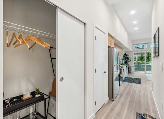 an open kitchen and living room with white walls and white closets and white doors