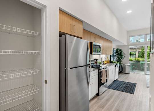 a kitchen with white appliances and wooden cabinets and a stainless steel refrigerator