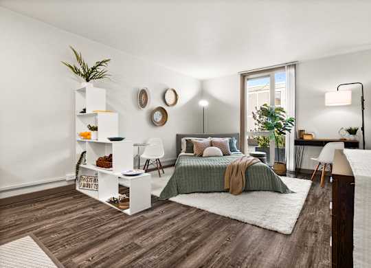 A bedroom with a bed, a desk, and a chair.