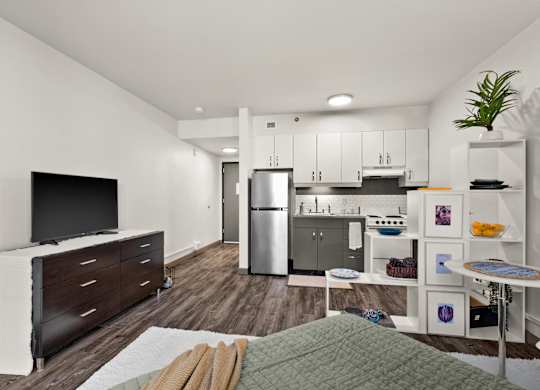 A modern kitchen with a refrigerator, microwave, and oven.