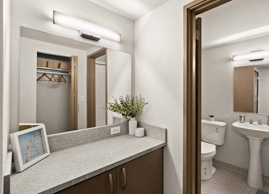 A bathroom with a toilet, sink, and mirror.