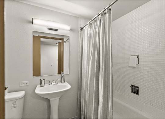 A white sink with a mirror above it in a bathroom.