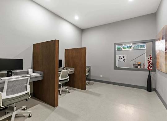 A room with a desk, chairs, and a painting on the wall. at Northpoint Apartments, Tacoma