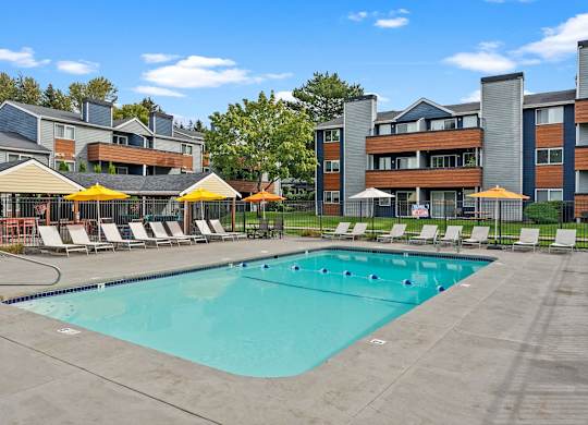 A large swimming pool surrounded by lounge chairs and umbrellas. at Northpoint Apartments, Washington