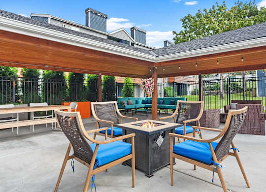 A patio with a table and chairs under a roof. at Northpoint Apartments, Washington, 98407