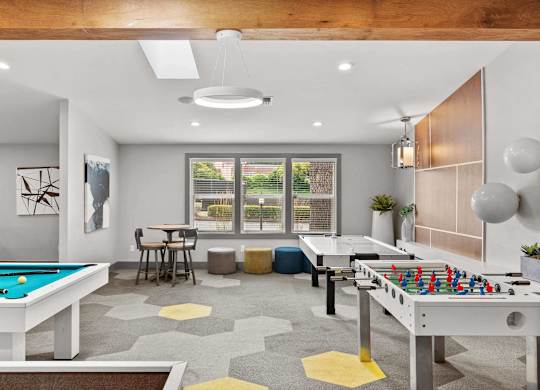 A room with a pool table and a foosball table. at Northpoint Apartments, Washington