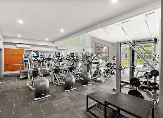 A gym with a variety of equipment including treadmills, stationary bikes, and weight machines. at Northpoint Apartments, Tacoma, Washington
