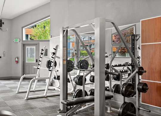 A gym with a variety of equipment including weights and a squat rack. at Northpoint Apartments, Tacoma, WA
