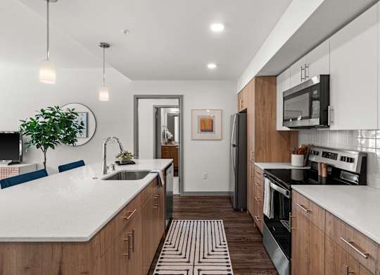 a large kitchen with white counter tops and wooden cabinets at Gage On Sixth, Tacoma