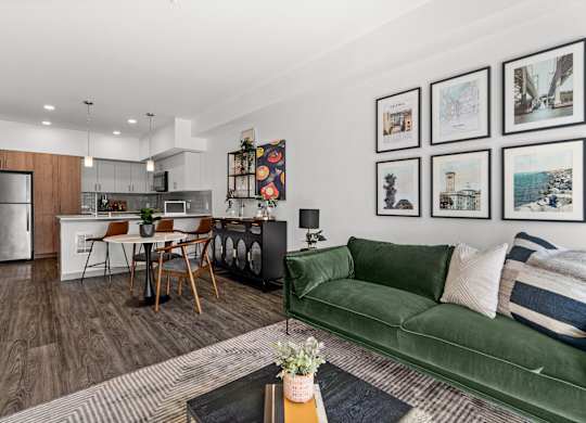 a living room with a green couch and a kitchen with a table and chairs at Gage On Sixth, Tacoma, 98406