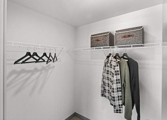 a walk in closet with two baskets on the wall and clothes hanging on a rack at Gage On Sixth, Tacoma, WA 98406
