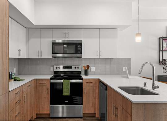 a kitchen with white cabinets and a stove and a sink at Gage On Sixth, Tacoma, 98406