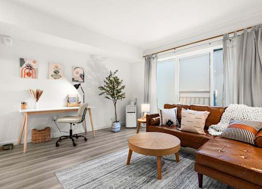 a living room with a leather couch and a desk and a window at Baldwyn, Seattle Washington