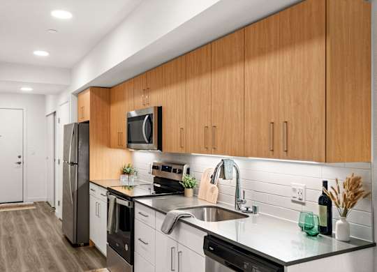 a kitchen with wooden cabinets and a stainless steel sink at Baldwyn, Seattle, WA