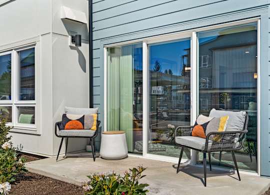 a patio with two chairs and a table outside a house at Gage On Sixth, Washington