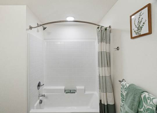 the bathroom has a shower and a tub with a shower curtain at Baldwyn, Washington, 98125