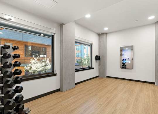 a large room with a wood floor and two windows at Baldwyn, Seattle, WA
