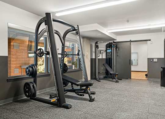 a gym with weights and other equipment in a room with glass doors at Baldwyn, Seattle, WA